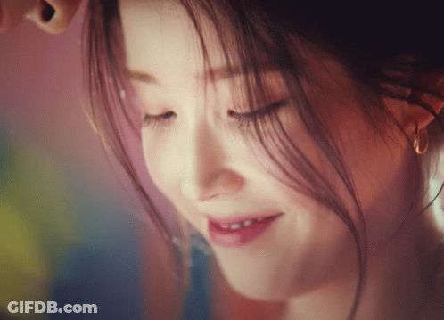 A Close Up Of A Woman 'S Face With Her Eyes Closed Smiling GIF