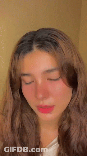 A Close Up Of A Woman 'S Face With Her Eyes Closed . GIF