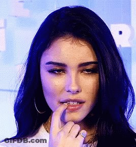 A Close Up Of A Woman 'S Face With Her Finger On Her Mouth GIF