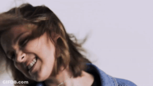 A Close Up Of A Woman 'S Face With Her Hair Blowing In The Wind . GIF