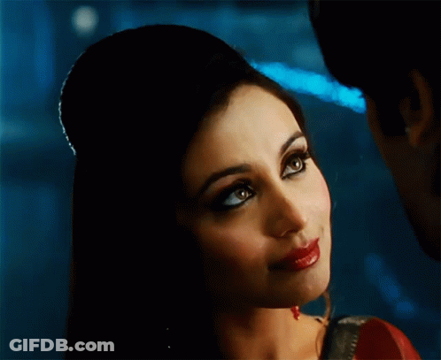 A Close Up Of A Woman 'S Face With Her Hair In A Bun GIF