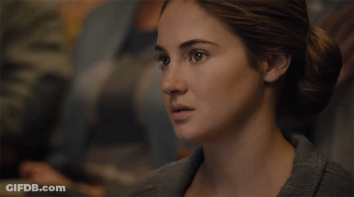 A Close Up Of A Woman 'S Face With Her Hair In A Bun GIF