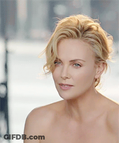 A Close Up Of A Woman 'S Face With Her Hair In A Bun GIF