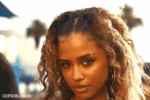 A Close Up Of A Woman 'S Face With Her Hair In A Ponytail GIF
