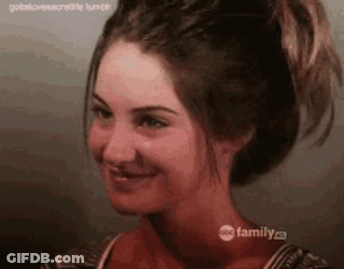 A Close Up Of A Woman 'S Face With Her Hair In A Ponytail GIF