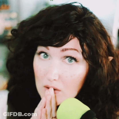 A Close Up Of A Woman 'S Face With Her Hand On Her Chin GIF