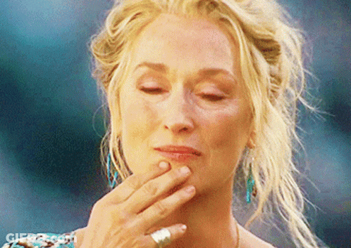A Close Up Of A Woman 'S Face With Her Hand On Her Chin GIF