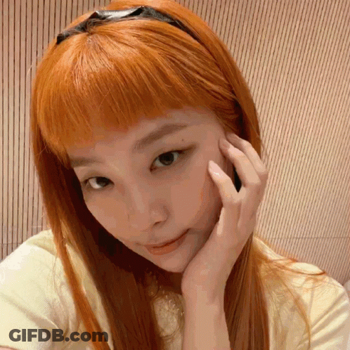 A Close Up Of A Woman 'S Face With Her Hand On Her Chin GIF