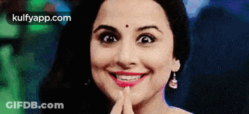 A Close Up Of A Woman 'S Face With Her Hand On Her Chin . GIF