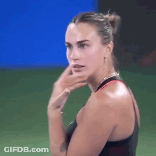 A Close Up Of A Woman 'S Face With Her Hand On Her Face . GIF