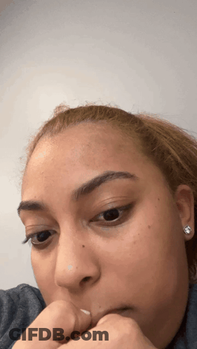 A Close Up Of A Woman 'S Face With Her Hand On Her Face GIF