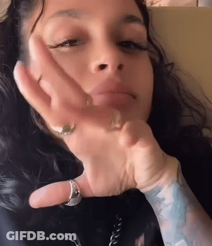 A Close Up Of A Woman 'S Face With Her Hand On Her Face . She Is Wearing A Ring On Her Finger . GIF