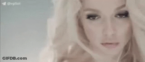A Close Up Of A Woman 'S Face With Her Hand On Her Head . GIF