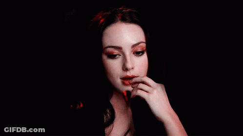 A Close Up Of A Woman 'S Face With Her Hand On Her Lips GIF