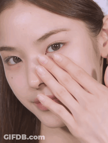 A Close Up Of A Woman 'S Face With Her Hand On It GIF