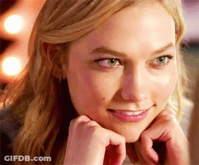 A Close Up Of A Woman 'S Face With Her Hands On Her Face And Smiling . GIF