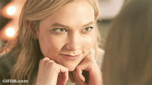 A Close Up Of A Woman 'S Face With Her Hands On Her Face . GIF