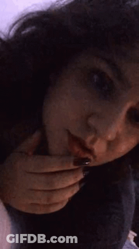 A Close Up Of A Woman 'S Face With Her Hands On Her Face . GIF