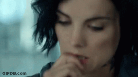 A Close Up Of A Woman 'S Face With Her Hands On Her Mouth . GIF