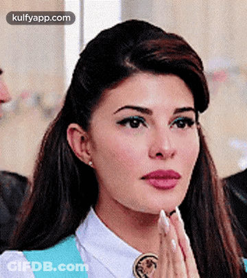 A Close Up Of A Woman 'S Face With Her Hands Together . GIF