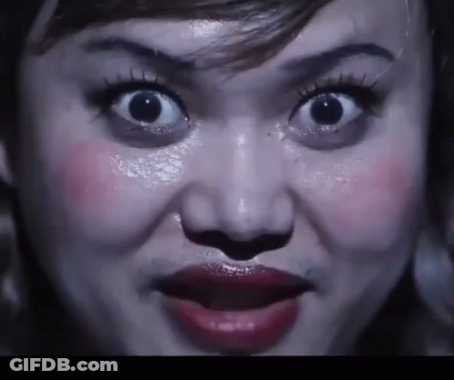 A Close Up Of A Woman 'S Face With Her Mouth Open GIF