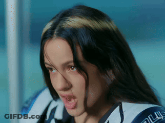 A Close Up Of A Woman 'S Face With Her Mouth Open And A Jacket That Says Blue On It GIF
