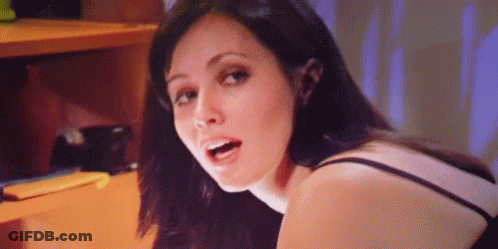 A Close Up Of A Woman 'S Face With Her Mouth Open And A Purple Background . GIF