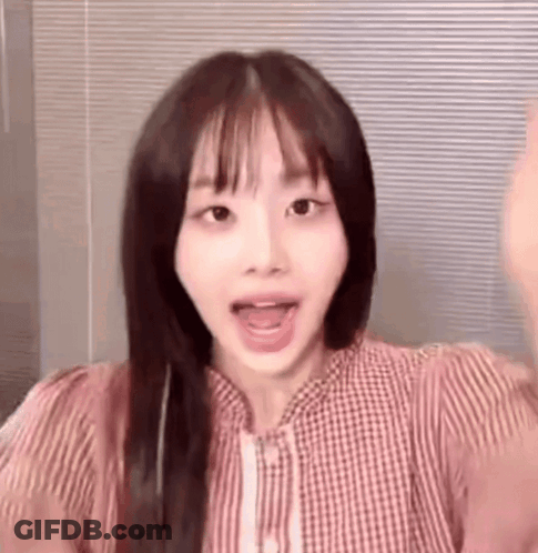 A Close Up Of A Woman 'S Face With Her Mouth Open And A Striped Shirt . GIF