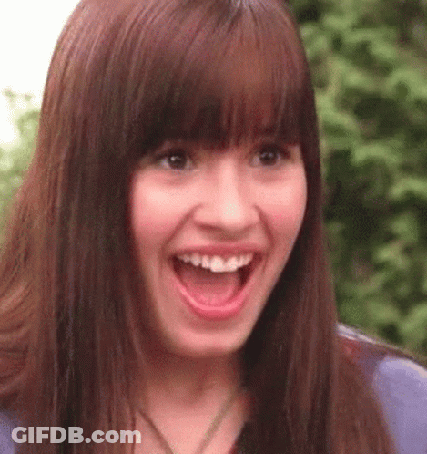 A Close Up Of A Woman 'S Face With Her Mouth Open And A Surprised Look On Her Face . GIF