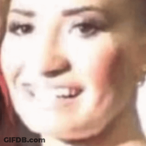 A Close Up Of A Woman 'S Face With Her Mouth Open And A White Background . GIF