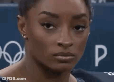 A Close Up Of A Woman 'S Face With Her Mouth Open And Earrings . GIF