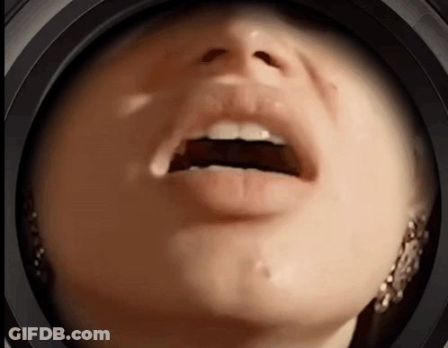 A Close Up Of A Woman 'S Face With Her Mouth Open And Earrings GIF