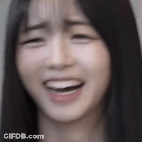 A Close Up Of A Woman 'S Face With Her Mouth Open And Her Eyes Closed . GIF