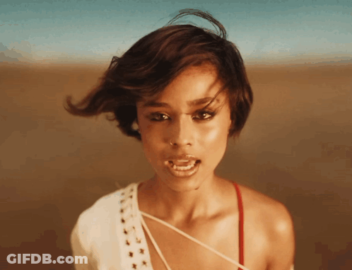A Close Up Of A Woman 'S Face With Her Mouth Open And Her Hair Blowing In The Wind GIF