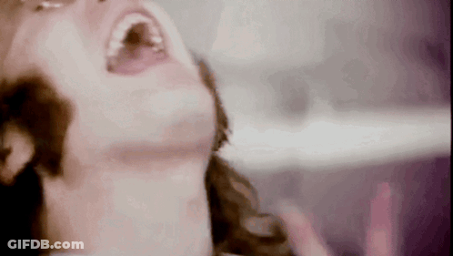 A Close Up Of A Woman 'S Face With Her Mouth Open GIF