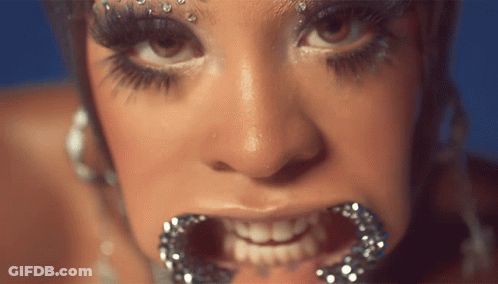A Close Up Of A Woman 'S Face With Her Mouth Open GIF