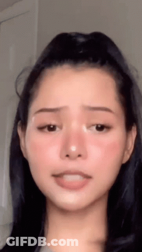 A Close Up Of A Woman 'S Face With Her Mouth Open GIF