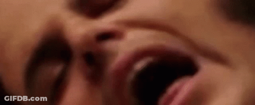 A Close Up Of A Woman 'S Face With Her Mouth Wide Open . GIF