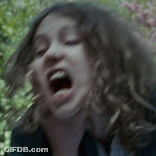 A Close Up Of A Woman 'S Face With Her Mouth Wide Open GIF