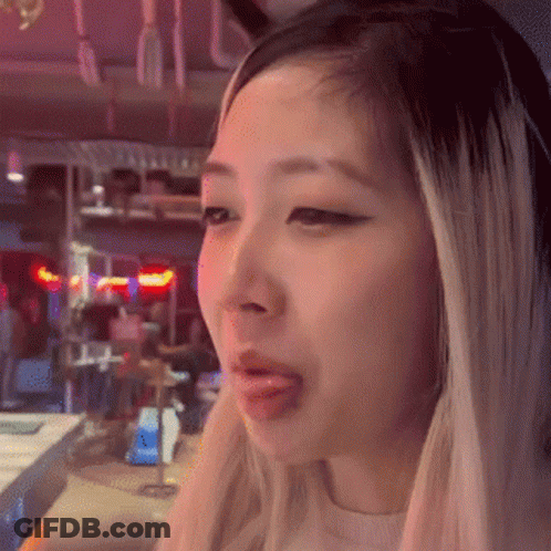 A Close Up Of A Woman 'S Face With Her Tongue Hanging Out . GIF