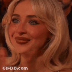A Close Up Of A Woman 'S Face With Her Tongue Hanging Out While Applauding . GIF