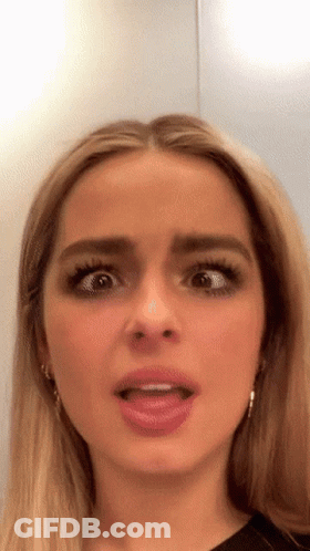 A Close Up Of A Woman 'S Face With Her Tongue Out GIF
