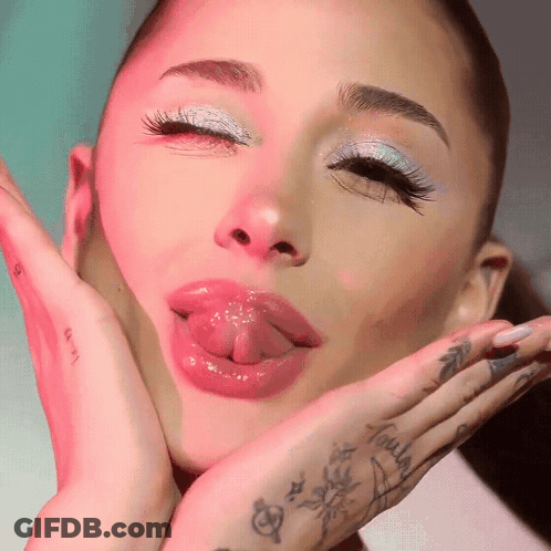A Close Up Of A Woman 'S Face With Her Tongue Out GIF