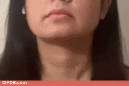 A Close Up Of A Woman 'S Face With Long Black Hair And Earrings . GIF