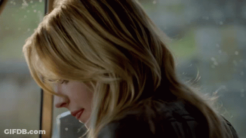 A Close Up Of A Woman 'S Face With Long Blonde Hair GIF