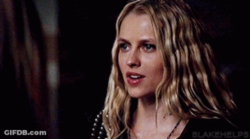 A Close Up Of A Woman 'S Face With Long Blonde Hair And Blue Eyes . GIF