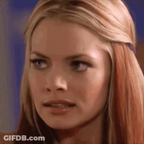 A Close Up Of A Woman 'S Face With Long Blonde Hair And Red Highlights . GIF