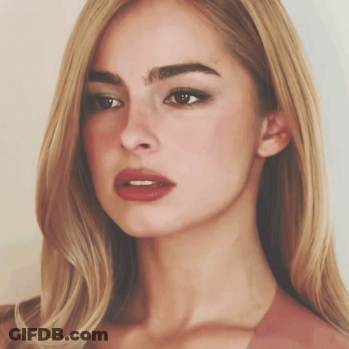 A Close Up Of A Woman 'S Face With Long Blonde Hair And Red Lips GIF
