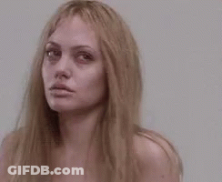 A Close Up Of A Woman 'S Face With Long Blonde Hair Without Makeup . GIF