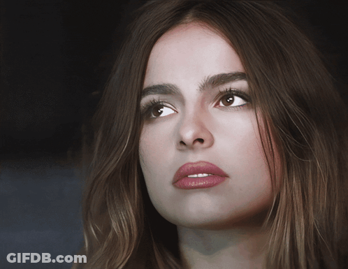 A Close Up Of A Woman 'S Face With Long Brown Hair GIF